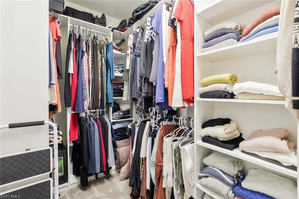 Custom-designed closet system featuring white shelving and multiple hanging rods