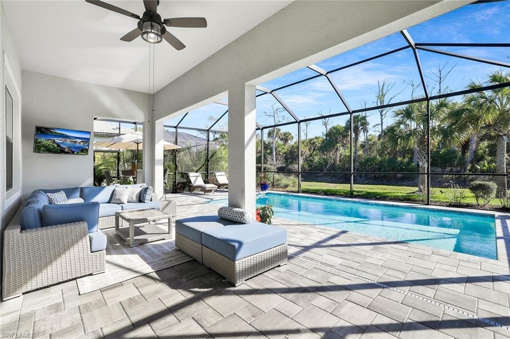 Covered outdoor living space featuring paver flooring, a vaulted ceiling, and a built-in ceiling fan
