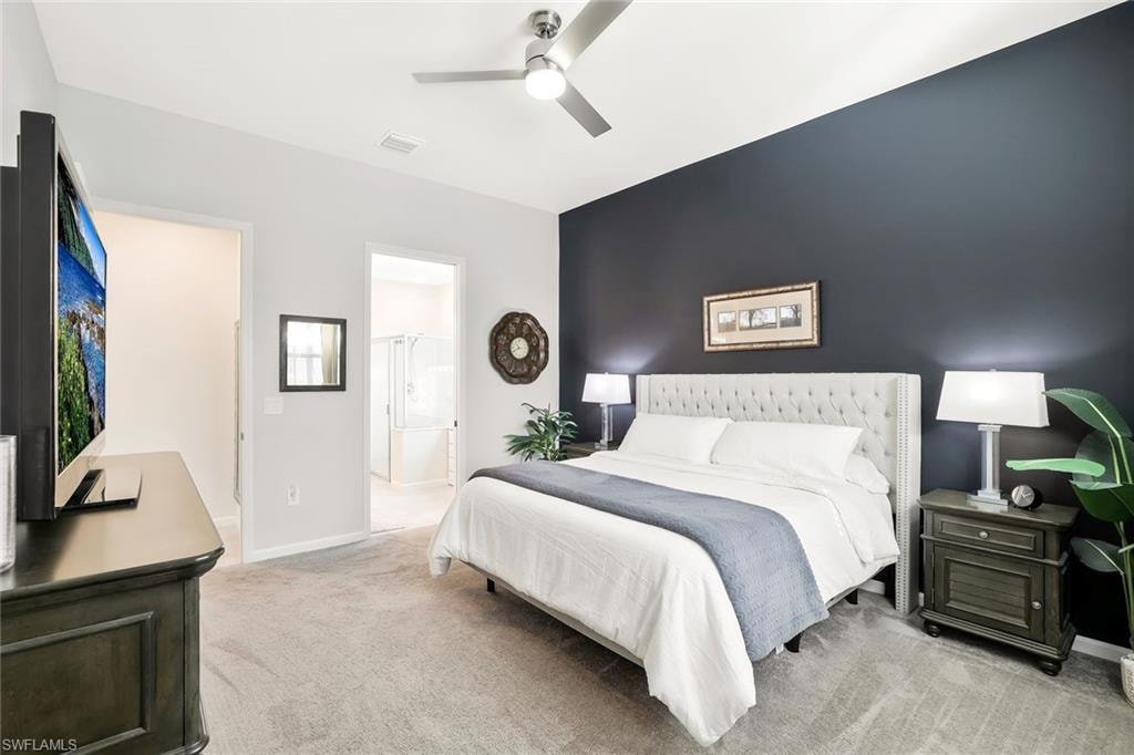 Spacious bedroom featuring light gray carpeting, a dark accent wall, and a contemporary ceiling fan