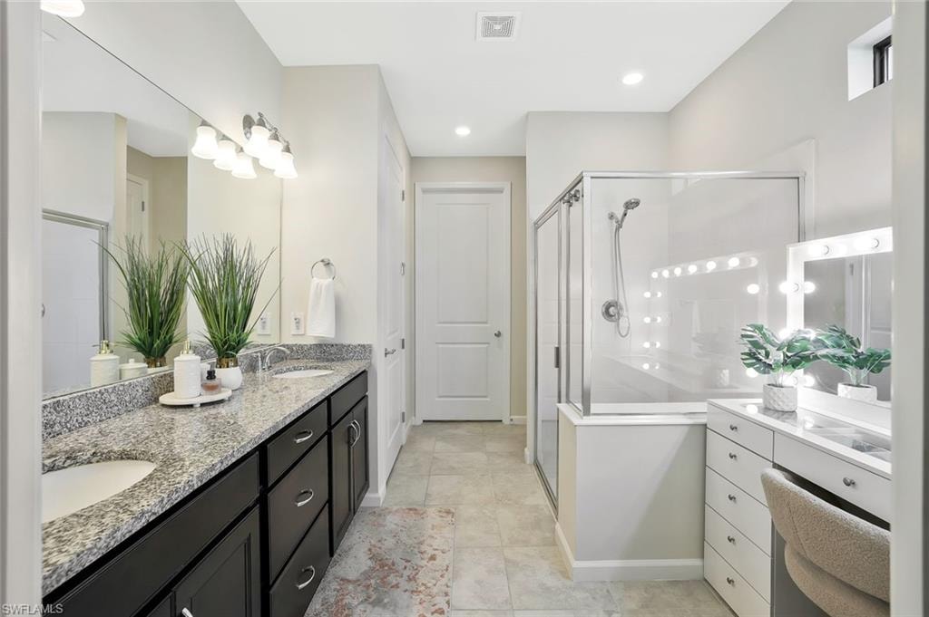 Spacious bathroom featuring a dual vanity with granite countertops, dark wood cabinetry, and integrated sinks