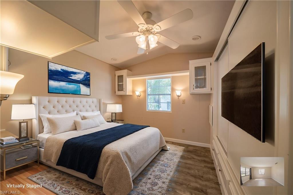 Bedroom with dark wood-type flooring, ceiling fan, and vaulted ceiling