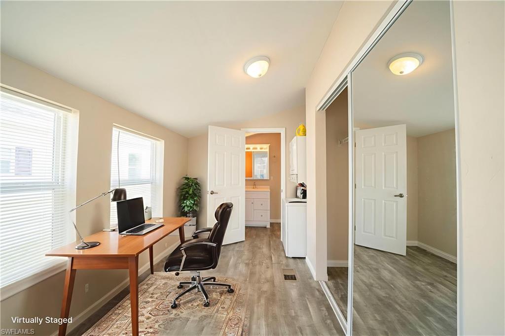 Office space with lofted ceiling and light wood finished floors