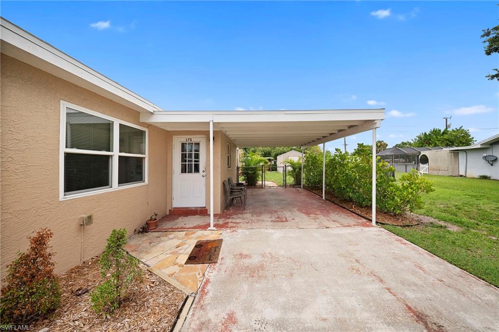 Carport entryway with a white paneled door and side windows