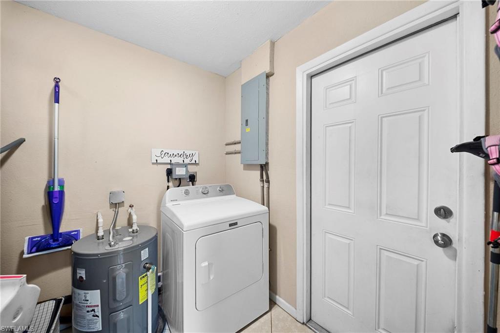 Dedicated utility area featuring a water heater, laundry appliance hookups, and tiled flooring