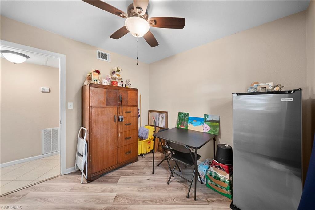 Room featuring wood-finish flooring, neutral wall paint, and a ceiling fan with integrated lighting