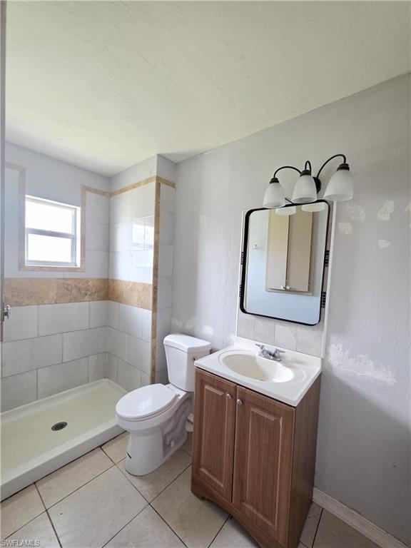 Bathroom featuring a shower with white subway tile and a decorative stone-look accent band