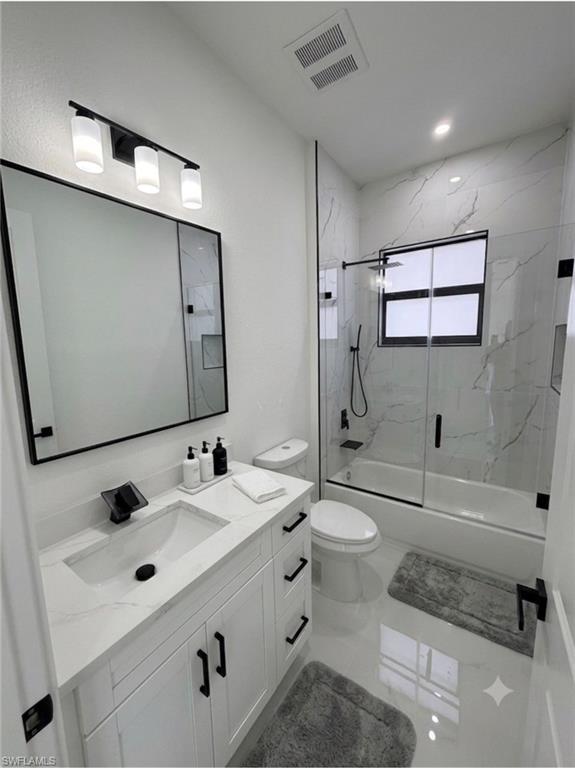 Modern bathroom featuring a white vanity with integrated sink, black fixtures, and a frameless glass shower enclosure