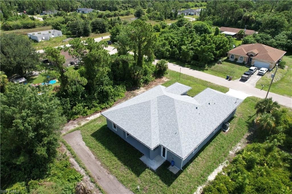 New construction home with a light gray shingle roof and blue exterior siding