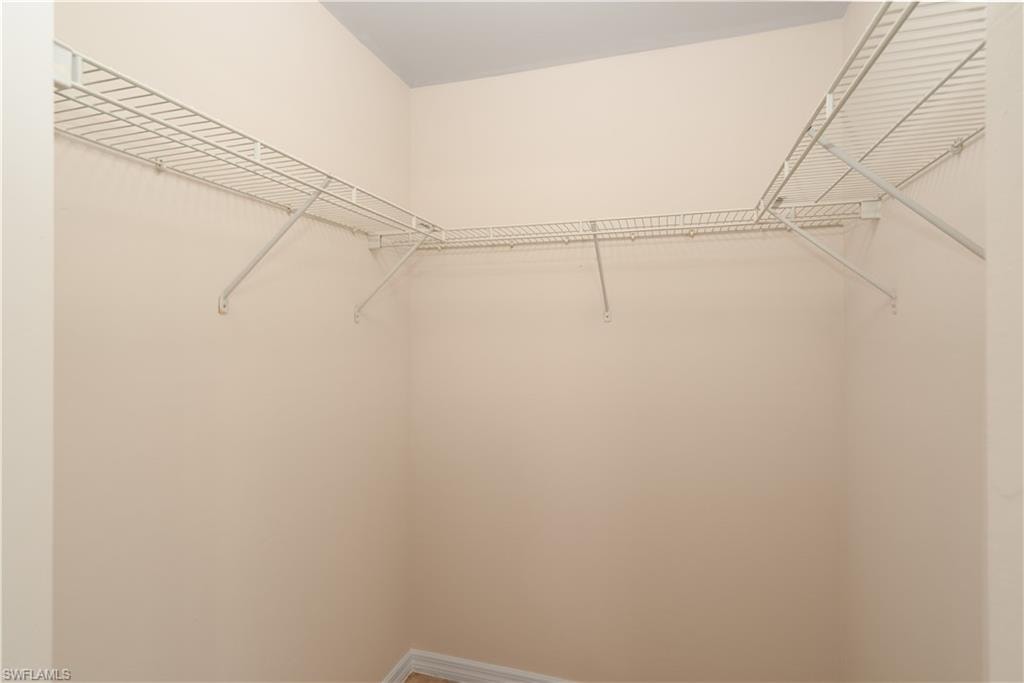 Corner closet with white wire shelving, extending along two walls