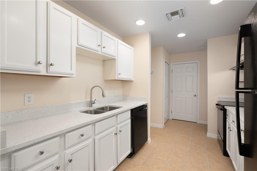 Kitchen featuring white cabinetry, light speckled countertops, a stainless steel double basin sink with a gooseneck faucet, and tiled flooring