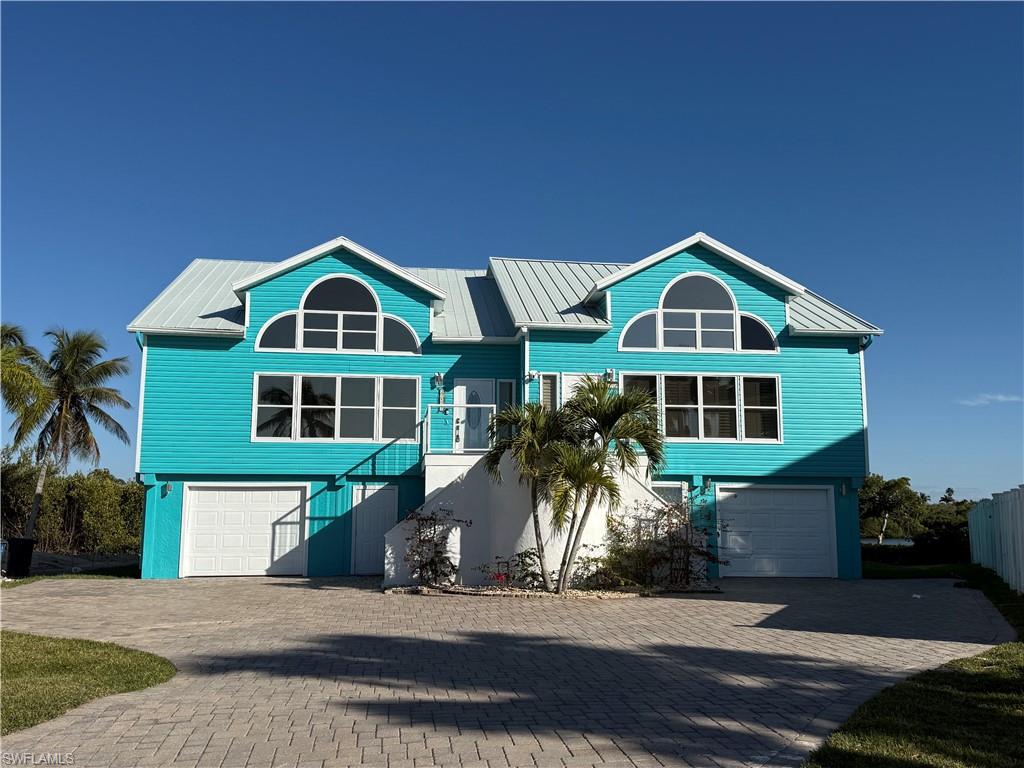 Vibrant teal exterior with a metal roof and an arched transom window