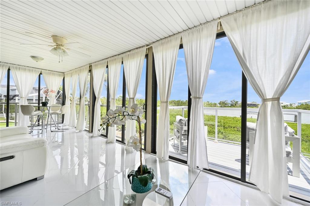 Sunroom featuring glossy tile flooring and a slatted ceiling with an integrated ceiling fan