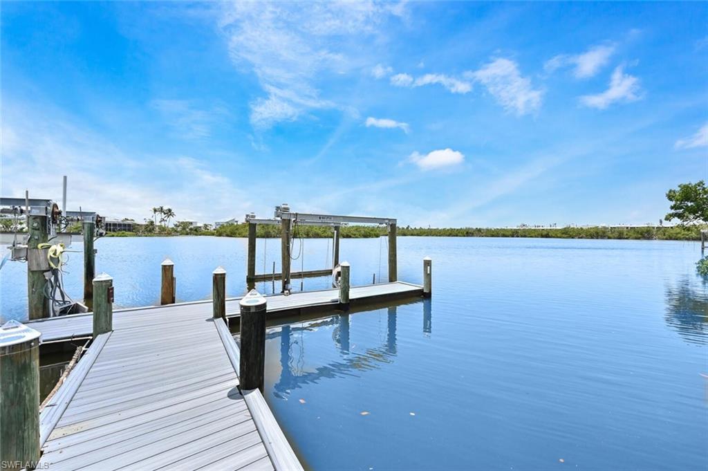 Waterfront property featuring a private boat dock with a lift system and multiple pilings