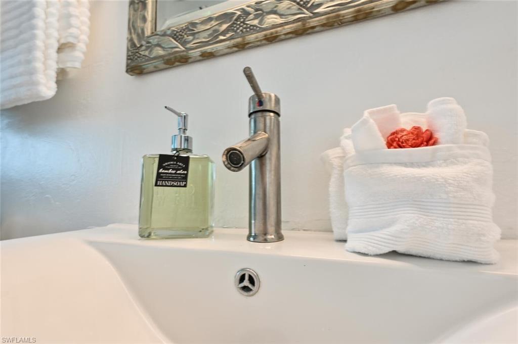 White ceramic sink with a brushed nickel faucet and a decorative mirror
