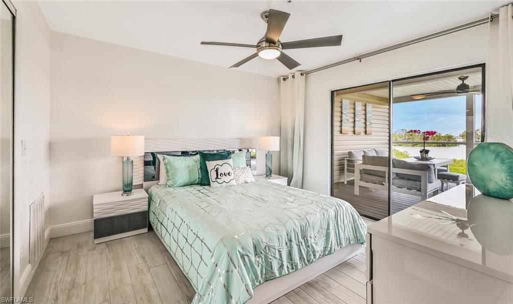 Bedroom featuring wood-finish flooring, a modern ceiling fan, and sliding glass doors opening to a covered patio