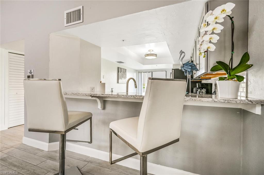 Kitchen pass-through featuring a granite-look countertop and under-counter storage