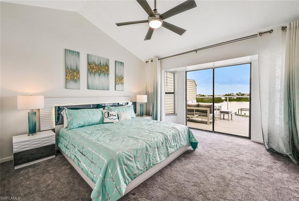 Spacious bedroom featuring vaulted ceilings, a contemporary ceiling fan, and plush gray carpeting
