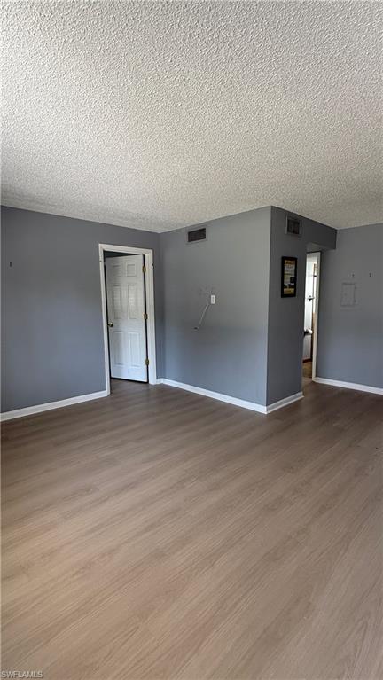 Spacious interior featuring fresh gray walls, wood-finish flooring throughout, and multiple closet spaces
