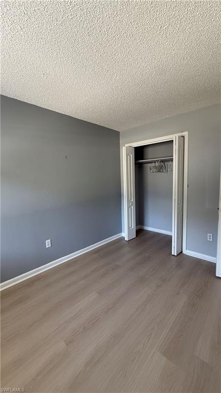 Neutral-toned wood-finish flooring with a textured ceiling
