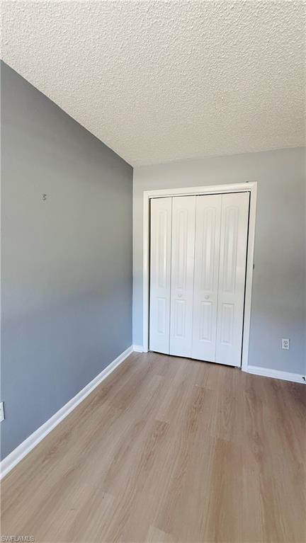 Wood-finish flooring, light gray wall paint, and white bi-fold closet doors