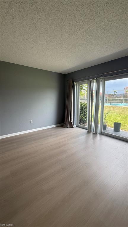 Wood-finish flooring with neutral wall tones and a textured ceiling