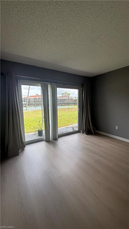 Sliding glass door, wood-finish flooring, textured ceiling, solid wall color