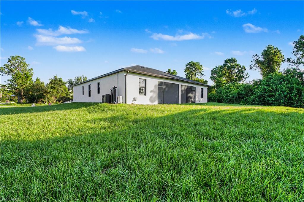 Expansive rear yard featuring green grass and established perimeter landscaping