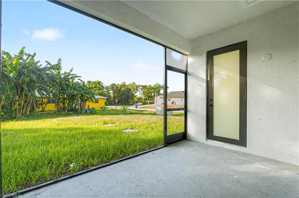 Expansive screened lanai featuring a concrete floor, textured exterior walls, and a contemporary frosted glass door