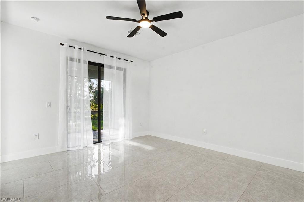 Spacious room featuring large format tile flooring, a contemporary ceiling fan, and a sliding glass door providing access to exterior space