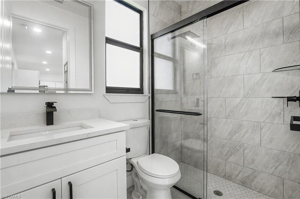 Modern bathroom featuring a glass-enclosed shower with subway tile surround and hexagonal floor tiles