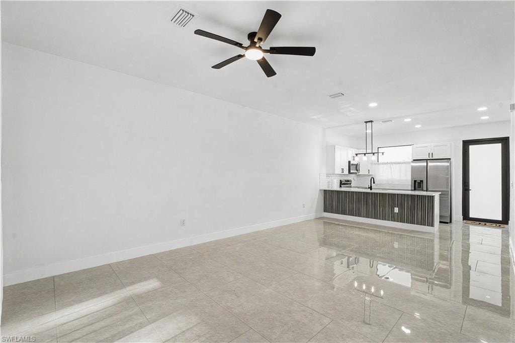 Open concept living space featuring large format tile flooring, a contemporary ceiling fan, and recessed lighting