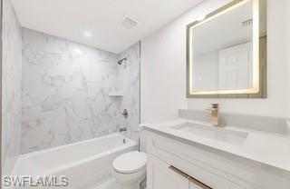 Bathroom featuring a white vanity with gold-tone hardware, a rectangular undermount sink, and a light-framed mirror