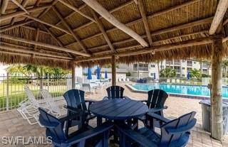 Covered outdoor seating area featuring a thatched roof and structural wood beams