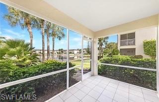 Screened lanai featuring white tile flooring and direct outdoor access