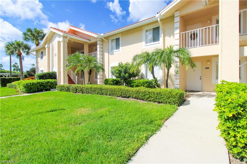View of front of home featuring a balcony and a front lawn