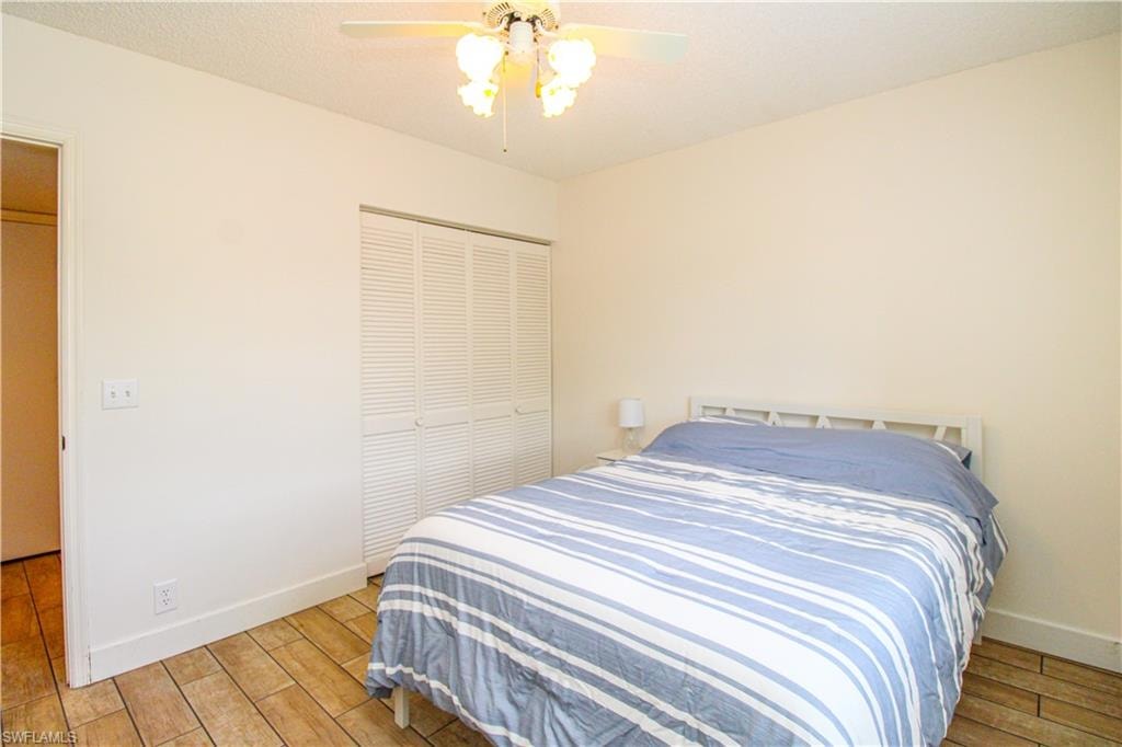 Bedroom featuring ceiling fan, light wood-type flooring, and a closet