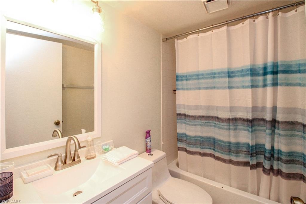 Full bathroom with vanity, shower / tub combo, and toilet