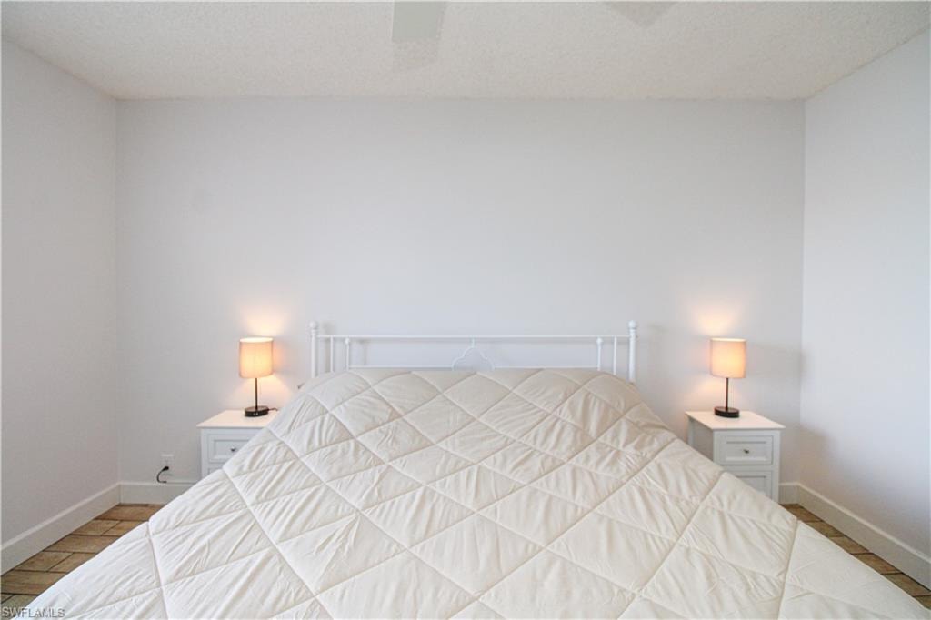Bedroom with ceiling fan and a textured ceiling