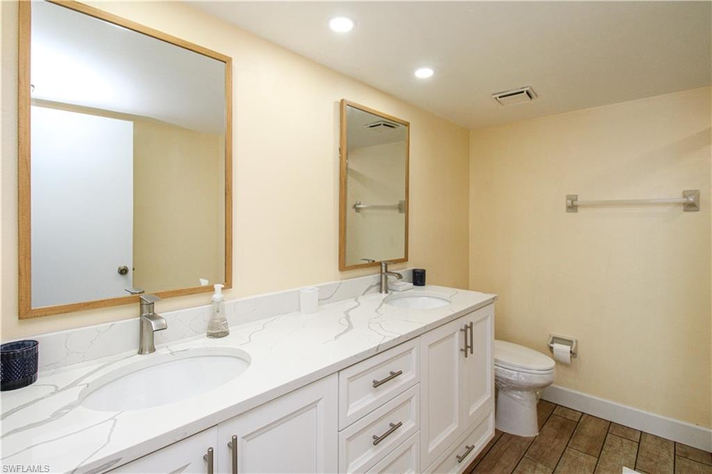 Bathroom with vanity, toilet, and hardwood / wood-style flooring