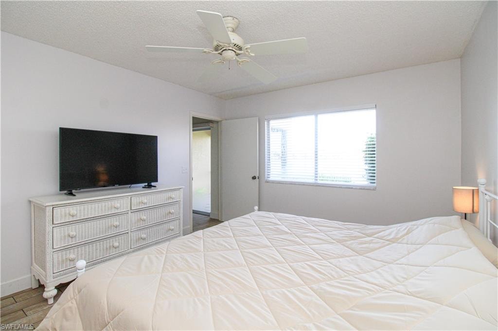 Bedroom featuring a textured ceiling, ceiling fan, and hardwood / wood-style flooring