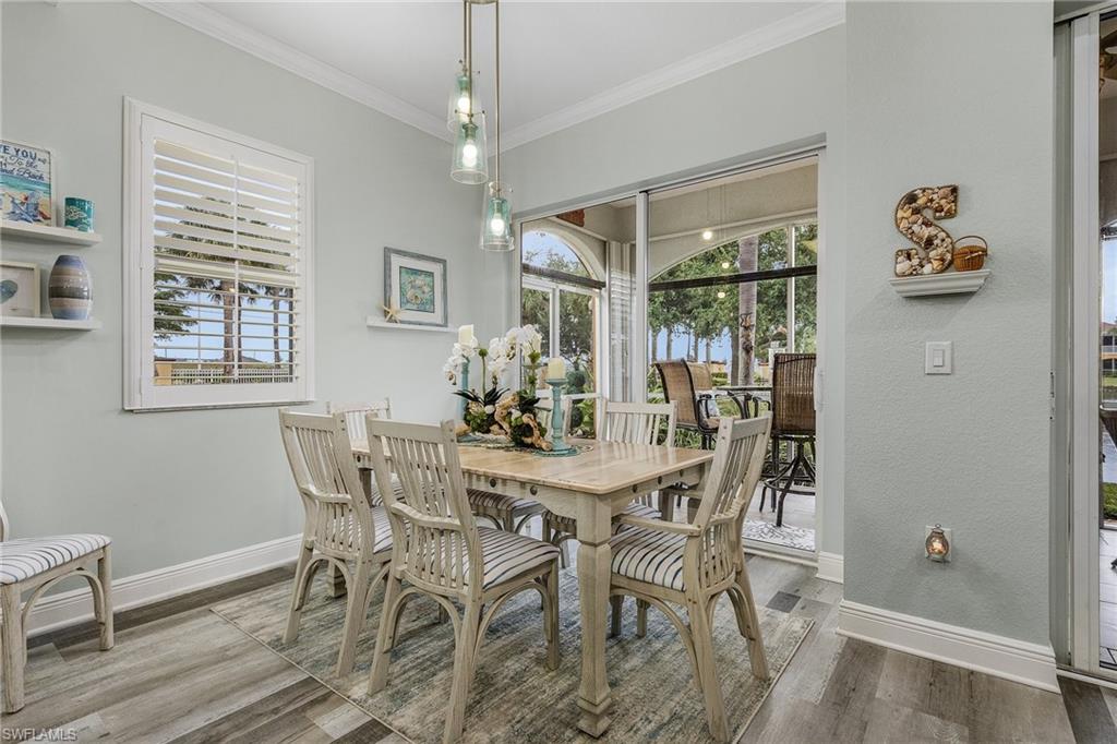 Dining area overlooks lanai and beautiful lake and landscaping.