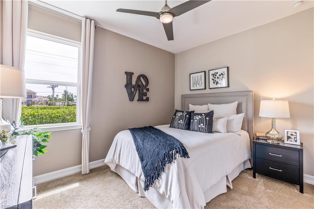 Carpeted room featuring a ceiling fan with integrated lighting, a window with white trim and curtains, and neutral-toned wall paint