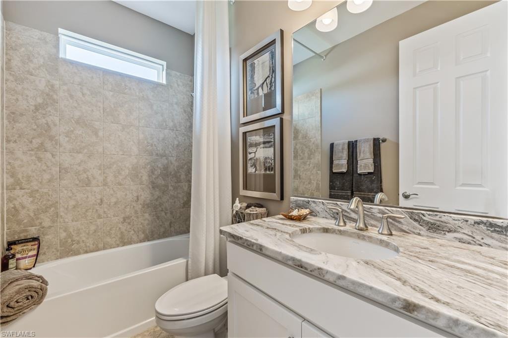 Spa-inspired bathroom featuring a marble-finish vanity countertop with dual sinks, chrome faucetry, and ample storage