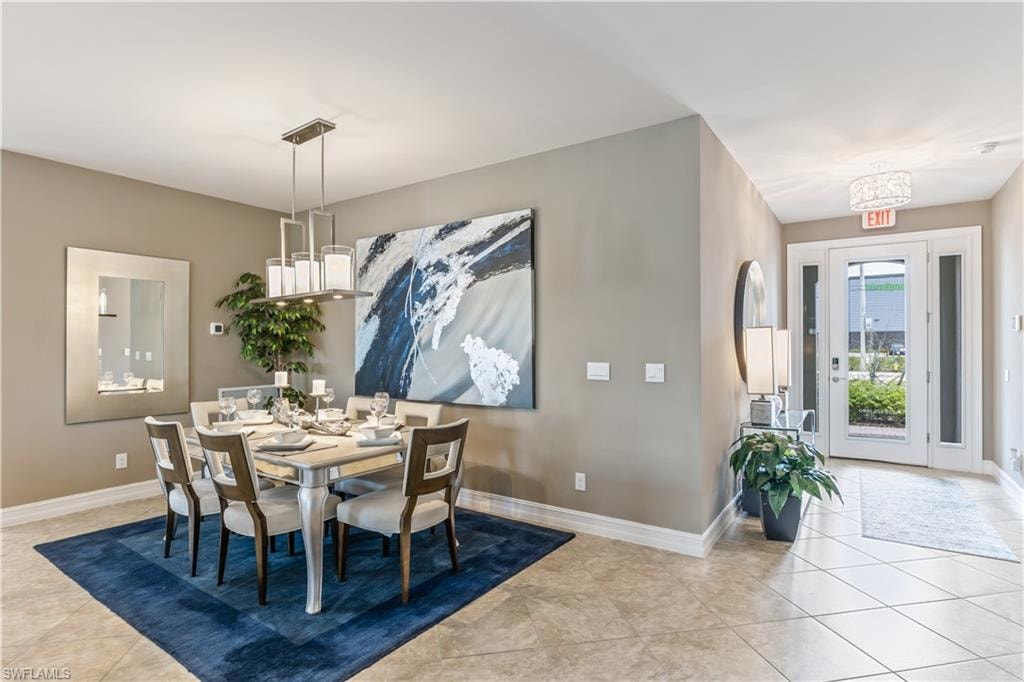 Elegant dining room featuring a light wood table with upholstered chairs, pendant lighting fixture, and a striking abstract blue artwork