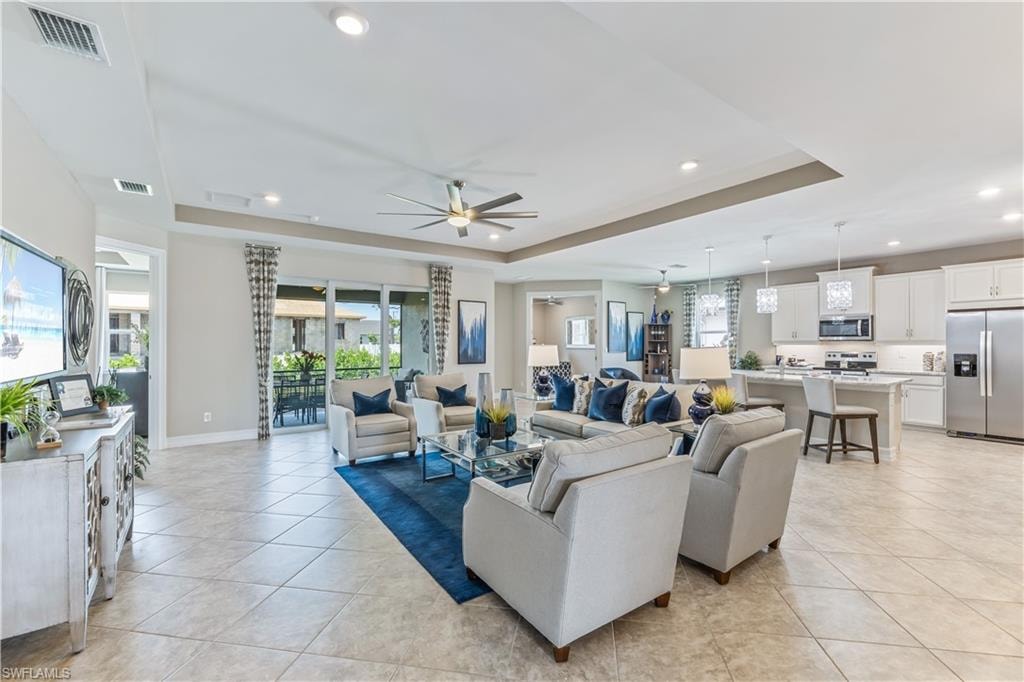 Spacious open-concept living area featuring large format tile flooring, recessed lighting, and a ceiling fan