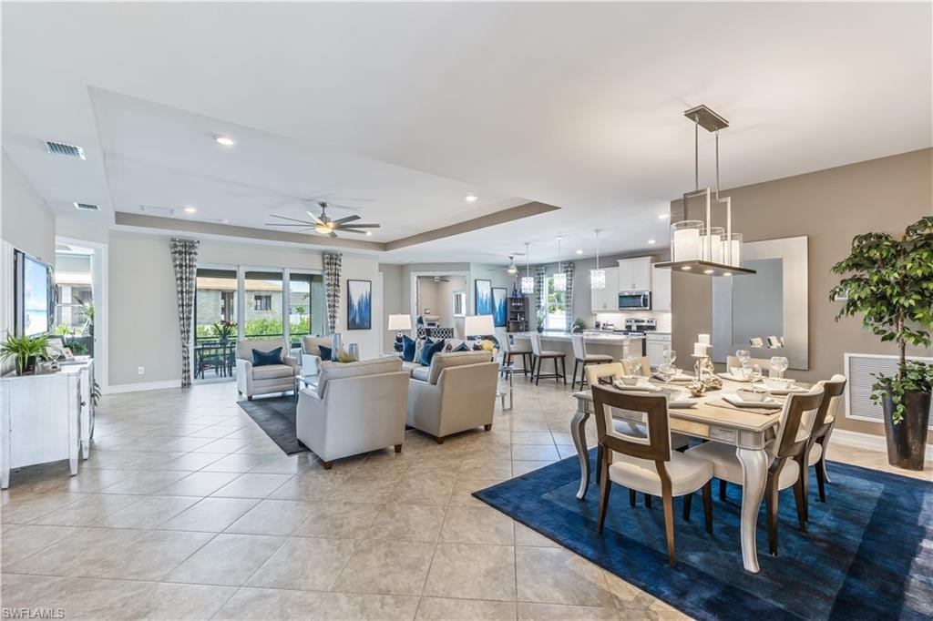 Open-concept living space showcasing tile flooring, recessed lighting, and a ceiling fan