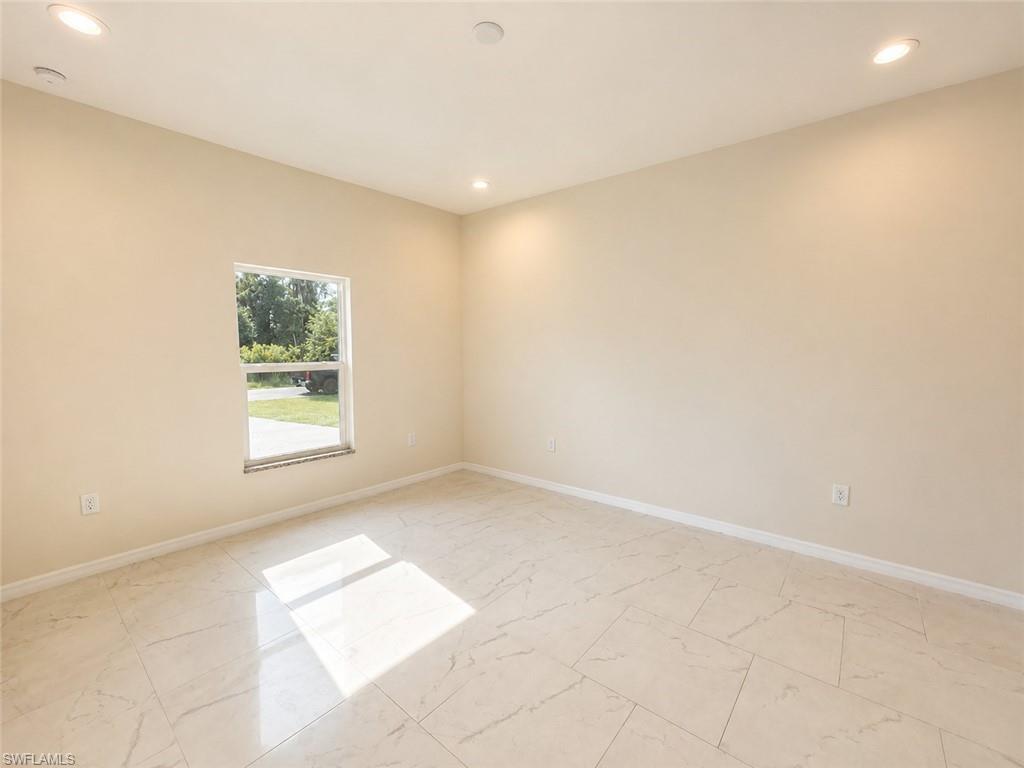 Bright and spacious room featuring neutral wall finishes, recessed ceiling lighting, and large window with natural light