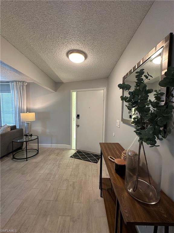 Entrance foyer featuring light hardwood / wood-style flooring and a textured ceiling
