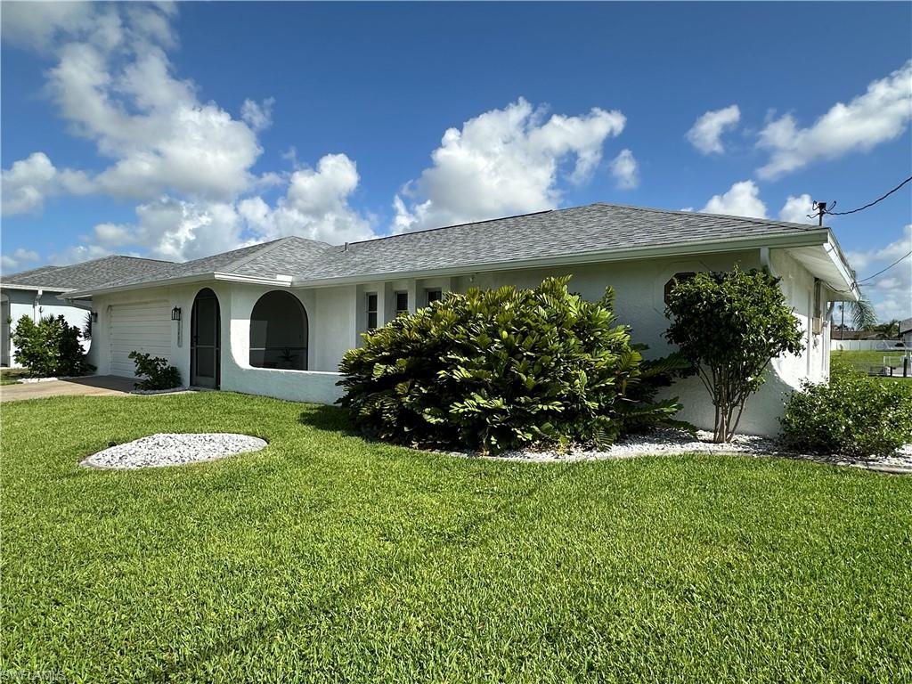 Single story home featuring a garage and a front yard