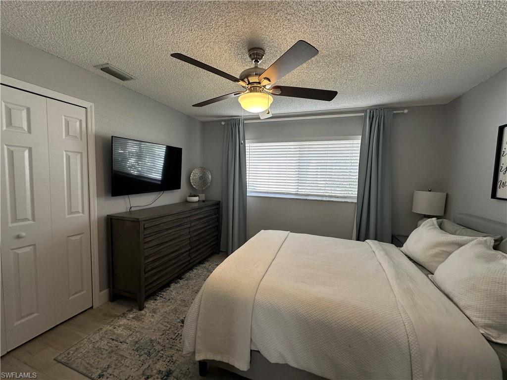 Bedroom featuring a textured ceiling, a closet, and ceiling fan